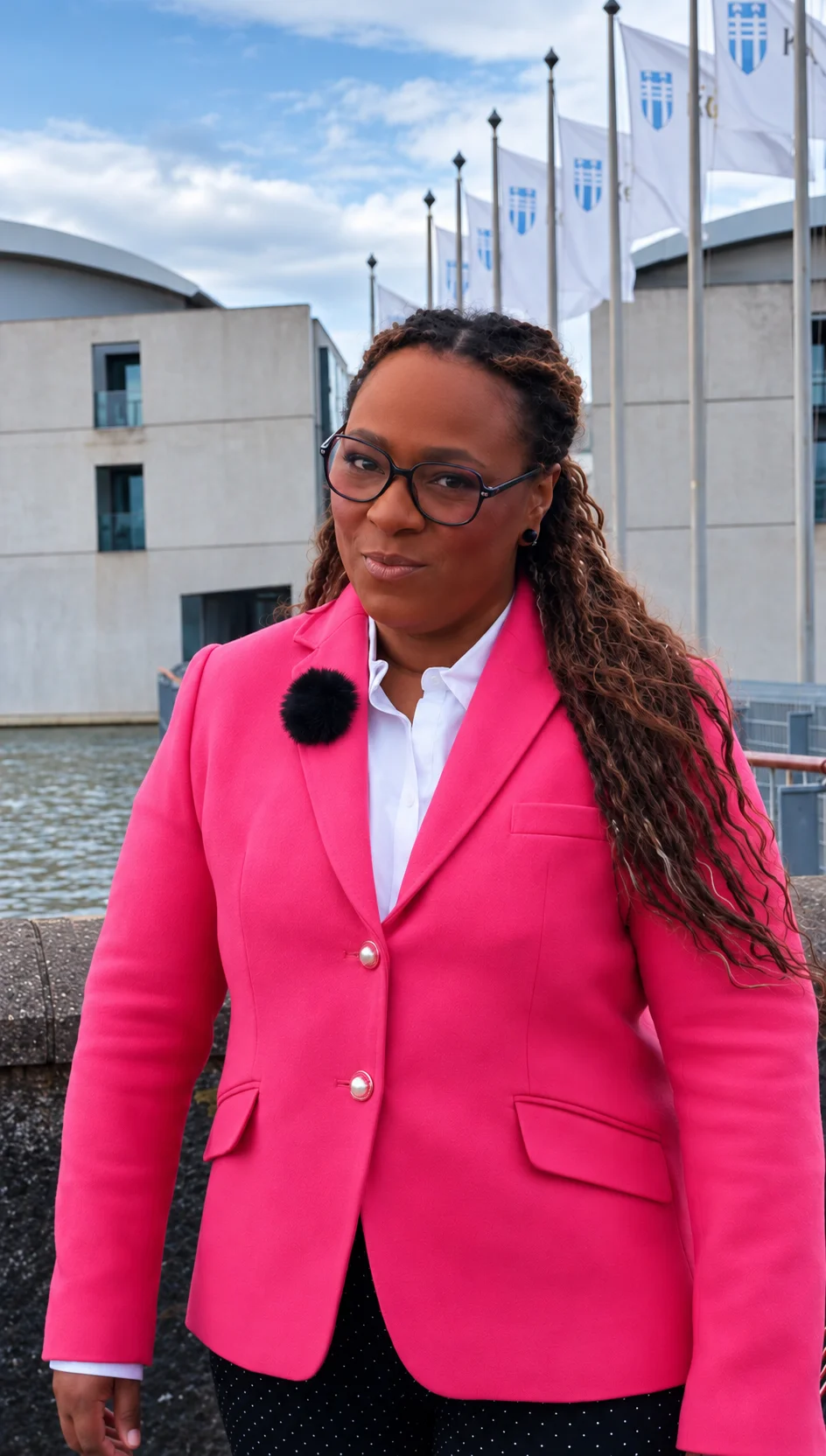 Nathalia in a pink jacket beside the waterfront